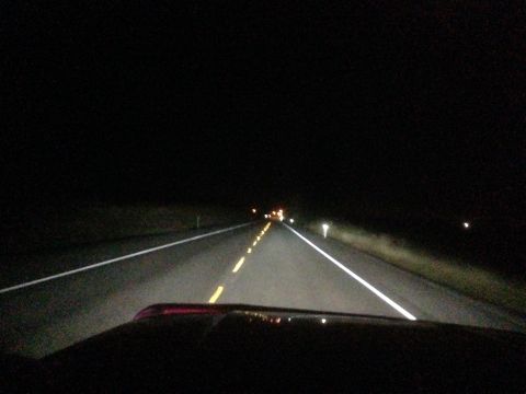 1992 Ford F-150 - Night driving shot taken over the hood of a dark-colored vehicle on a two-lane rural highway, with headlights washing over the yellow cente…
