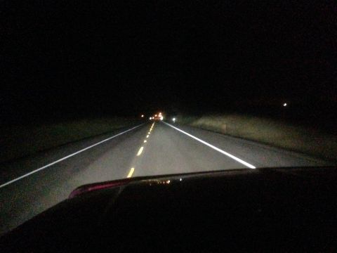 1992 Ford F-150 - View from inside a vehicle driving on a dark road at night, with other cars visible in the distance.
