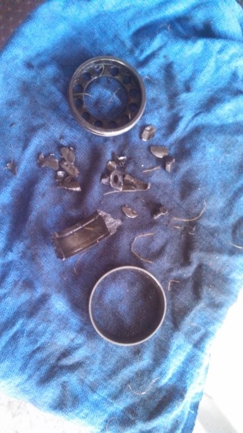 1979 Ford Bronco - Damaged bearing parts are laid out on a blue cloth after disassembly.