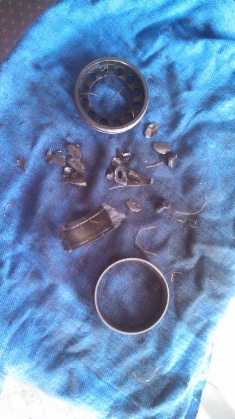 1979 Ford Bronco - The remnants of a failed wheel bearing lie disassembled on a blue fabric surface.