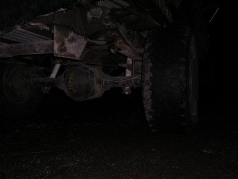 1990 Ford F-150 - The rear axle and suspension components of a vehicle are visible in this low-light shot.