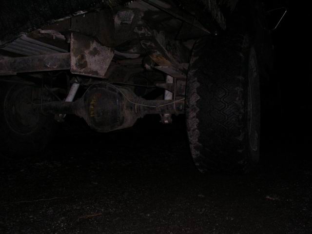 Underside view of a vehicle's rear axle and tire