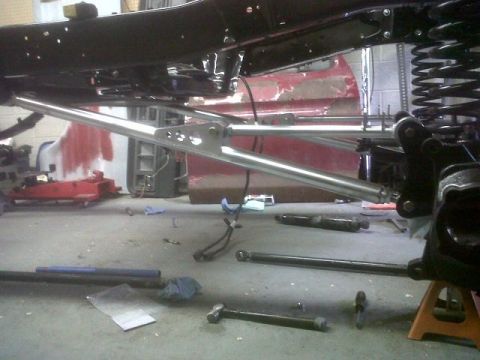 1979 Ford Bronco - Vehicle suspension components and underbody detail in a workshop setting.