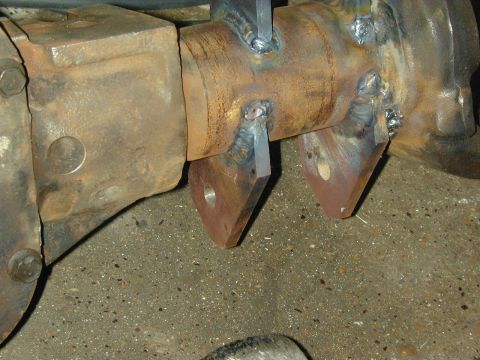 1996 Ford Bronco - Close-up of a rusty differential housing with newly welded metal brackets.