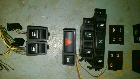 1989 BMW 3 Series - Collection of BMW interior control switches and wiring harnesses laid out on a floor.