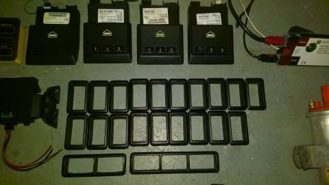 1989 BMW 3 Series - Several BMW electronic control units and numerous rectangular bezels are laid out on a gray surface.