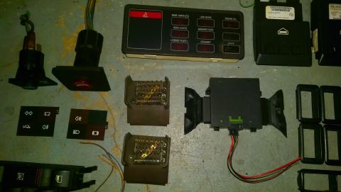 1989 BMW 3 Series - Collection of electrical parts, including dashboard switches and control modules, likely for a BMW E30.