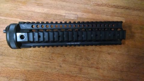 1996 Ford Bronco - A tactical AR-15 handguard with rail mounts and engraved text is shown on a wooden surface.
