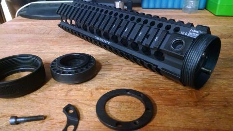 1996 Ford Bronco - Disassembled AR-15 handguard and associated components laid out on a wooden surface.