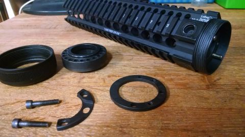 1996 Ford Bronco - AR-15 rifle handguard and associated parts laid out on a wooden table.