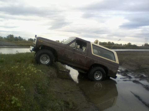 1980 Ford Bronco - This 1980 Ford Bronco is navigating a muddy terrain with water.
