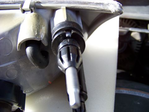 1999 Mercury Grand Marquis - Detail of a vehicle's headlight assembly, focusing on the mounting hardware and adjustment mechanism.