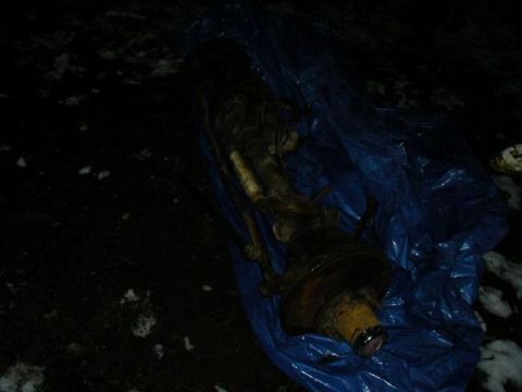 1990 Ford F-150 - A Dana 60 axle assembly is partially covered by a blue tarp on the ground.