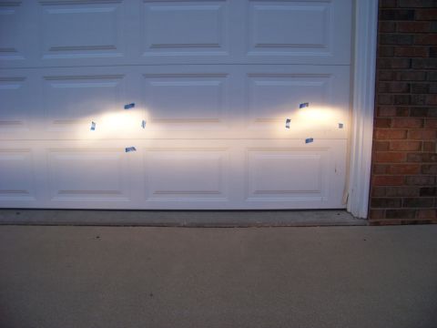 1999 Mercury Grand Marquis - Headlights are taped off and aimed at a garage door, likely for adjustment.