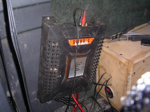 1990 Ford F-150 - A car stereo amplifier is mounted inside a vehicle, next to a wooden speaker box.