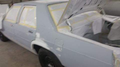 1991 Ford LTD Crown Victoria - A sedan, likely undergoing bodywork and painting, is shown with its trunk open and windows taped off.