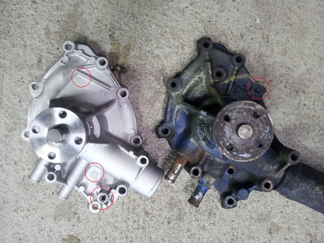 New and old Ford water pumps side-by-side on concrete. One is silver, the other is dark blue/black