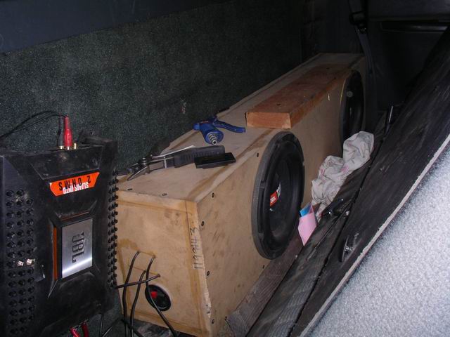 JBL amplifier and custom subwoofer box with two 12-inch speakers inside a vehicle