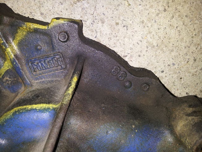 Cast iron Ford part with yellow and blue paint, showing 'FORD' logo and '68' casting date