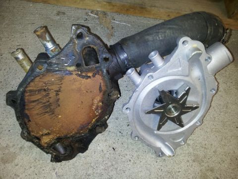 1968 Ford Mustang - Comparison of a used and a new water pump, with a coolant hose visible.