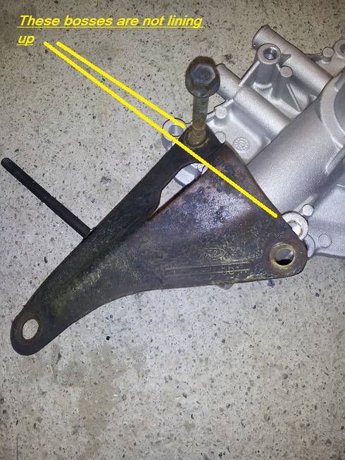 Engine bracket with yellow lines pointing out alignment issue. Part of engine block visible