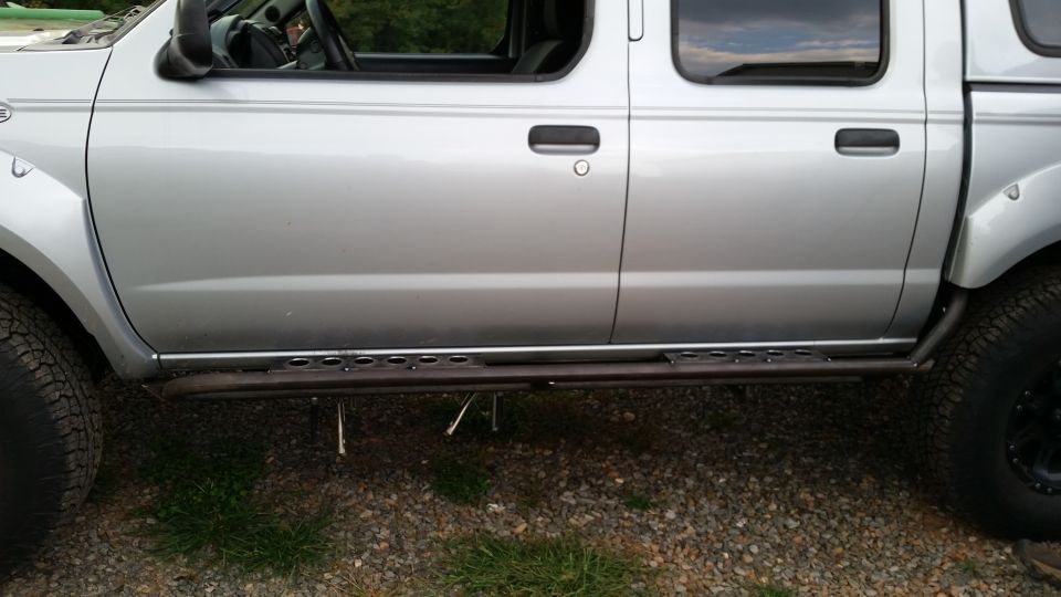 side of silver pickup truck with aftermarket side steps