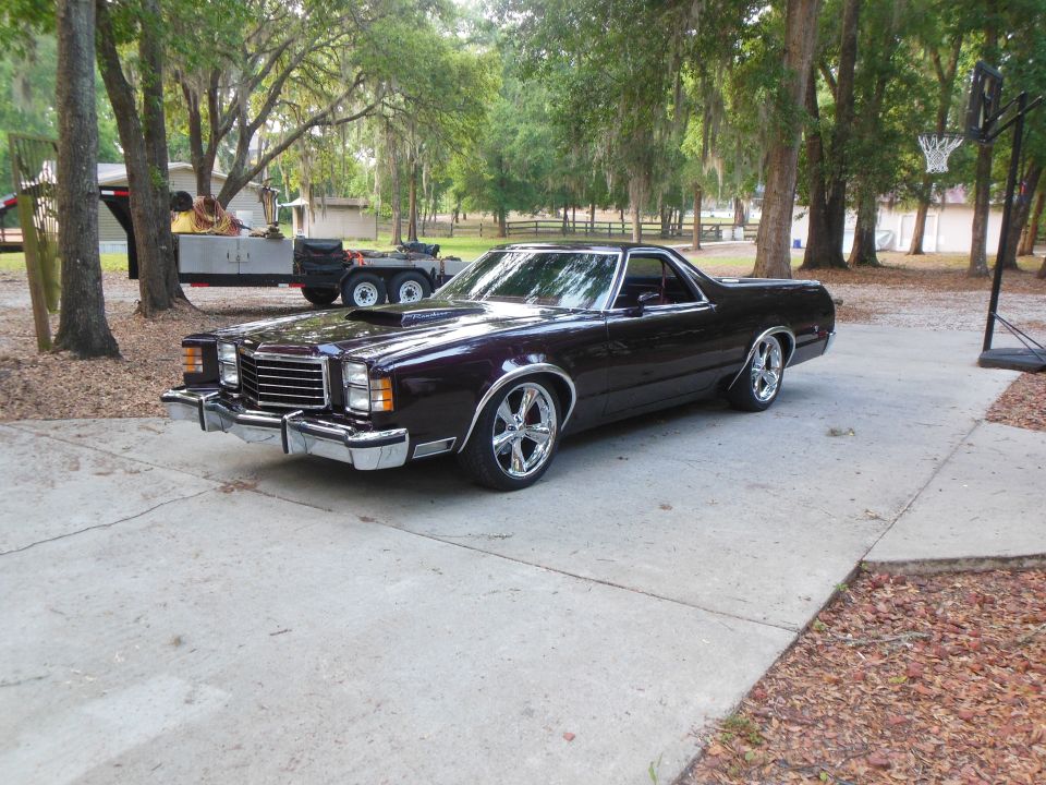Dark purple 1979 Ford Ranchero with chrome wheels and hood scoop parked on a driveway