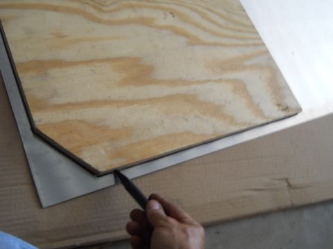 1992 Ford Bronco - A hand uses a pencil to trace a shape onto a piece of plywood laid over a metal sheet.