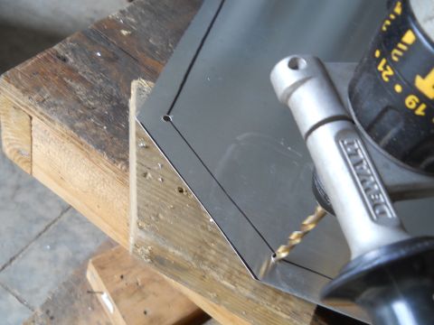 1992 Ford Bronco - A DeWalt drill is used to make a hole in a metal sheet supported by a wooden surface.