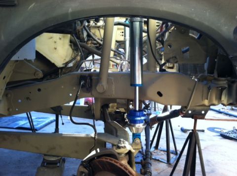 1995 Ford Bronco - Close-up view of a vehicle's suspension system, showing the shock absorber and frame components.