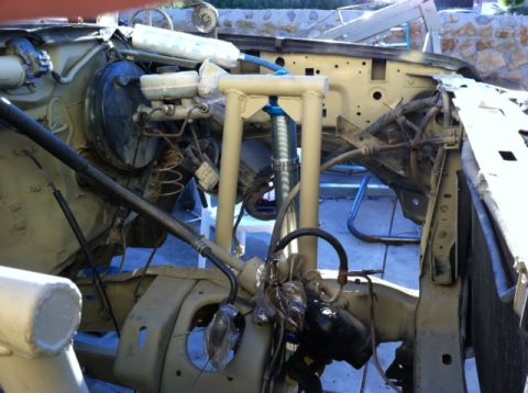 1995 Ford Bronco - Vehicle engine bay undergoing repair work, showing various mechanical components and suspension parts.