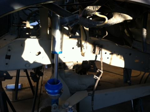 1995 Ford Bronco - Undercarriage view of a vehicle's suspension system, showing shock absorbers and frame components.