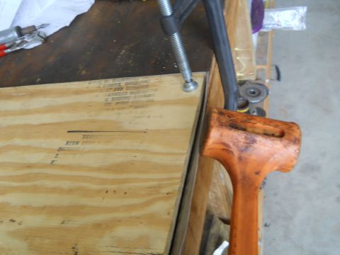 1992 Ford Bronco - Workbench setup with tools including a clamp and mallet, and some text on plywood.