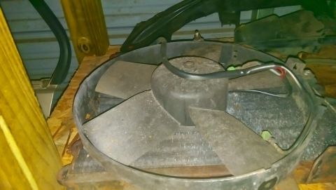 1989 BMW 3 Series - A radiator fan, likely a replacement part, is shown in a cluttered environment with wooden supports.