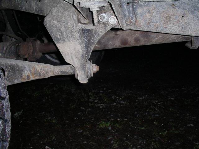 Close-up of a rusty truck suspension component, possibly a radius arm bracket