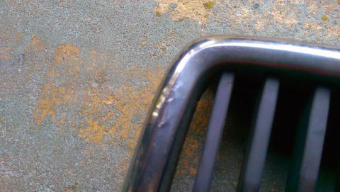 1989 BMW 3 Series - Close-up of a chrome grille with vertical slats, showing a portion of the textured background.