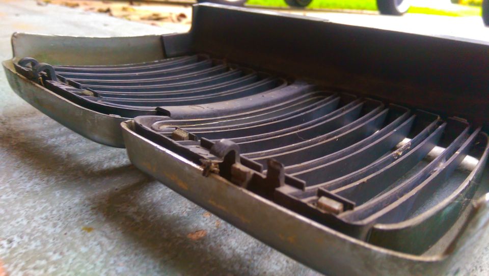 Close-up of a car grille section with horizontal slats and metal trim