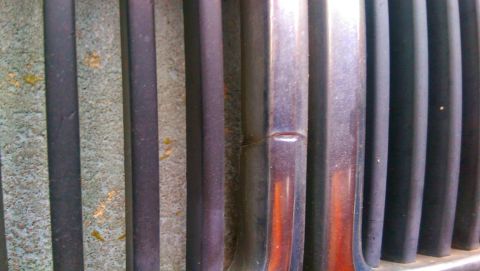 1989 BMW 3 Series - A close-up view of a car's grille, showing textured and metallic vertical slats.