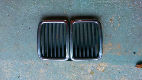 1989 BMW 3 Series - Two BMW kidney grilles are shown from a top-down perspective on a weathered surface.