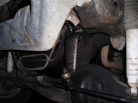 1990 Ford F-150 - Close-up of the vehicle's undercarriage, showing steering and suspension components with signs of wear and grease.