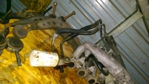 1989 BMW 3 Series - Engine and suspension parts are piled up, with an oil filter and intake manifold visible.