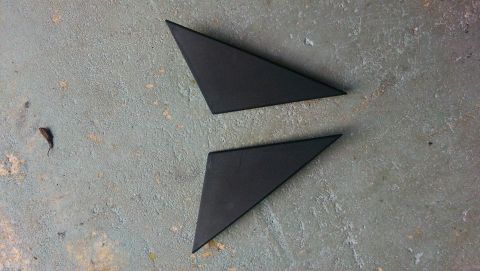 1989 BMW 3 Series - Two black triangular trim pieces are shown on a textured concrete surface.