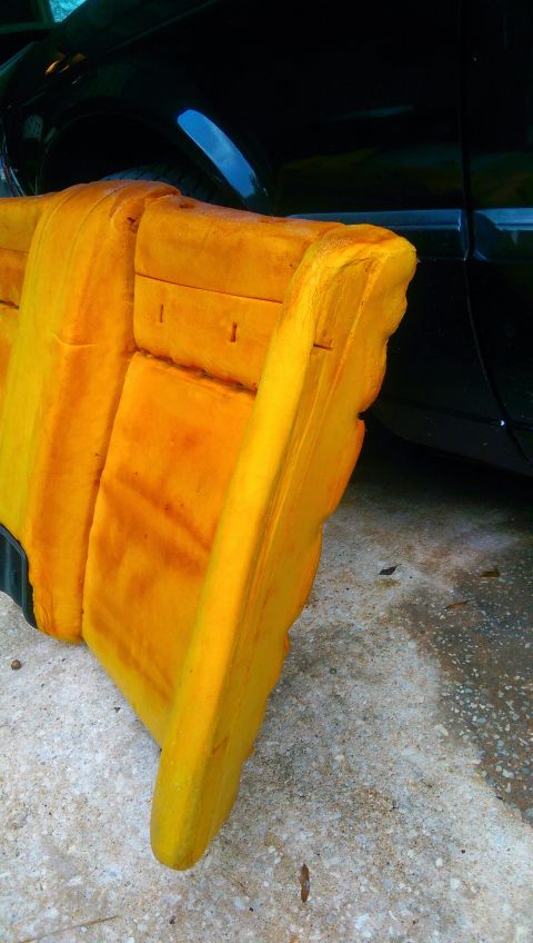 1989 BMW 3 Series - Close-up of yellow car seat foam, with a black vehicle visible behind it.