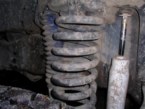 1990 Ford F-150 - Vehicle suspension components, including a coil spring and shock absorber, are shown in this close-up view.