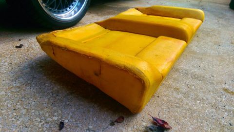 1989 BMW 3 Series - This is a close-up of yellow seat foam, with a wheel visible in the background, suggesting it is a car part.