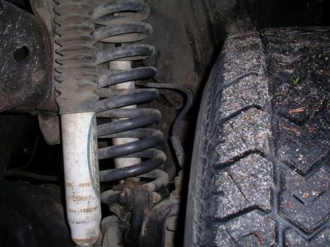 1990 Ford F-150 - Close-up view of a vehicle's front suspension system, showing a coil spring and shock absorber.