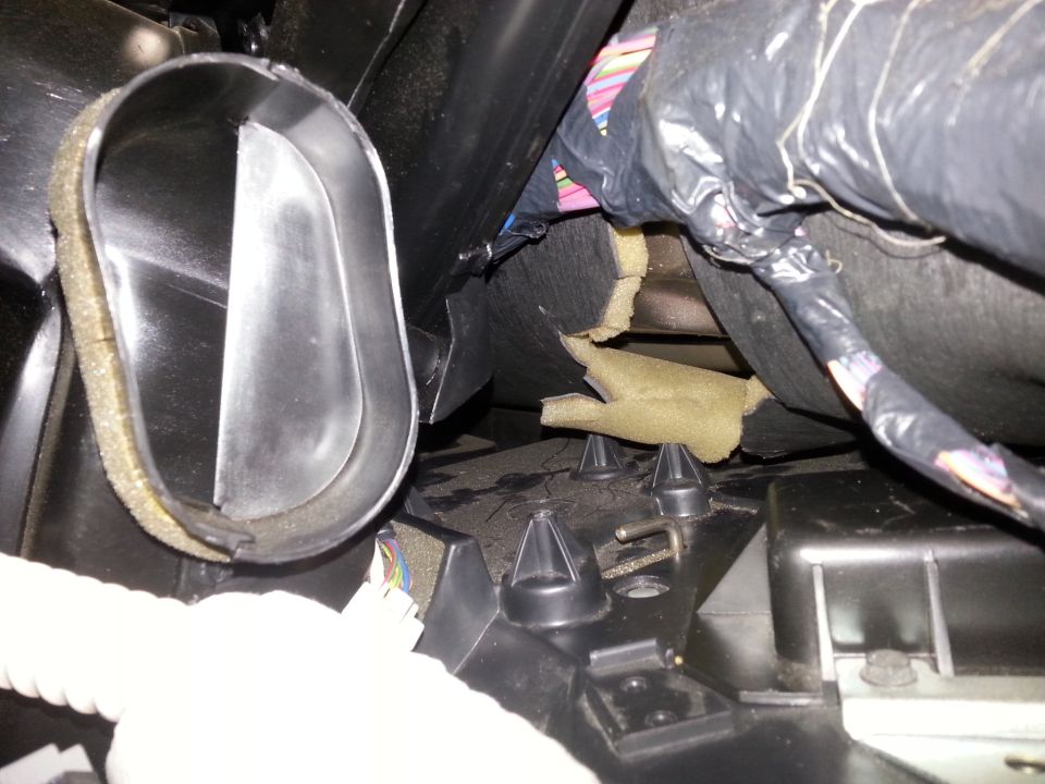 Close-up of car interior air duct with insulation and bundled wires