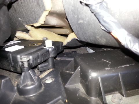 2003 Ford Crown Victoria - Close-up view of a vehicle's interior HVAC blend door actuator and surrounding components.