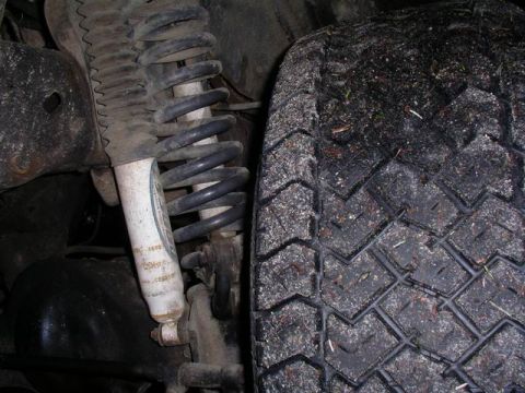 1990 Ford F-150 - Close-up of the front suspension and tire on a 1990 Ford F-150.