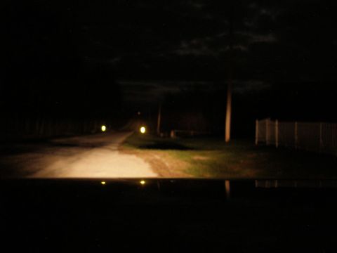 2008 Hyundai Accent - View from inside a vehicle at night, looking out at a dimly lit road with reflections on the dashboard.